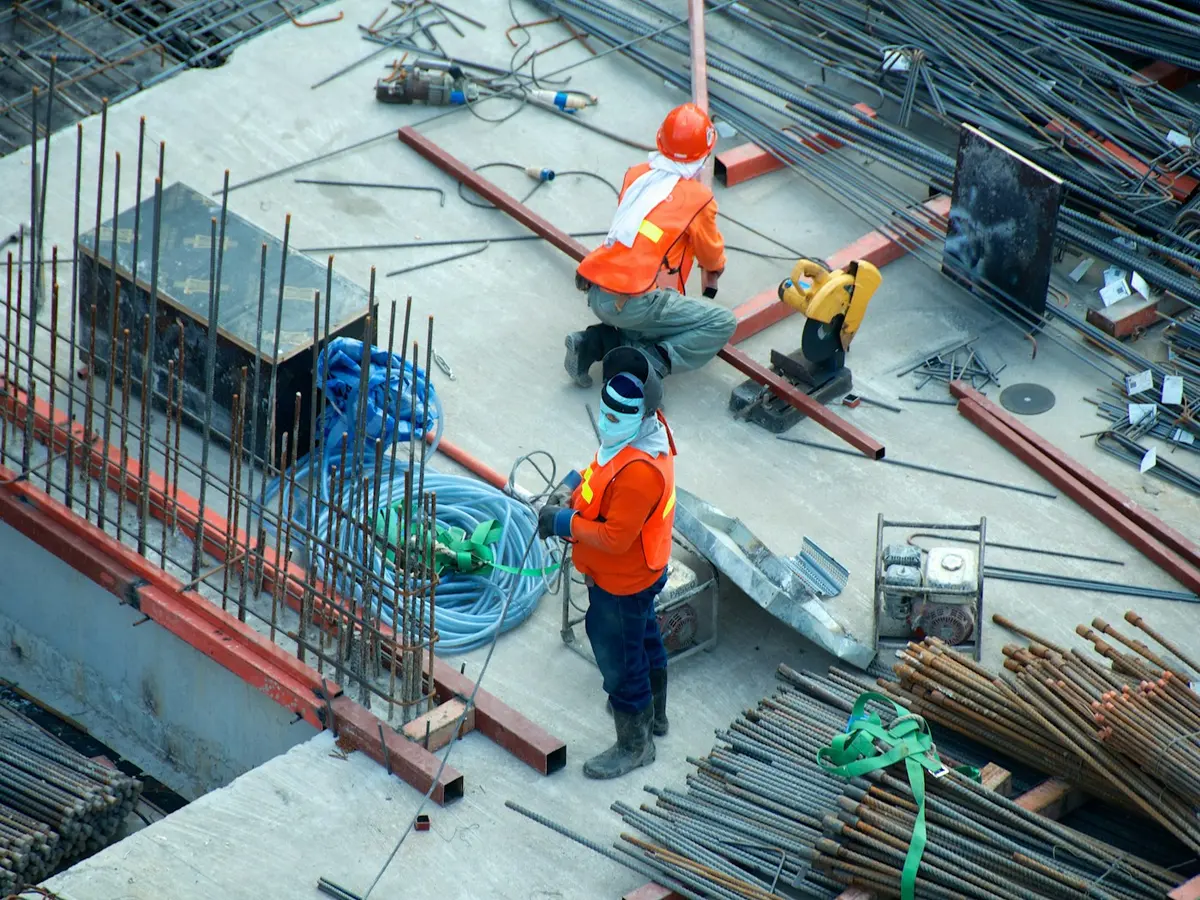 Construction workers in high-visibility clothing on a building site, representing trades and contractors.
