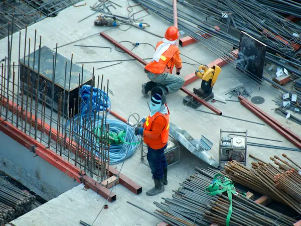 Construction workers in high-visibility clothing on a building site, representing trades and contractors.